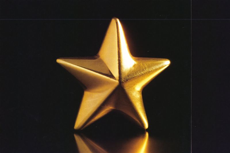A polished gold star on a dark surface